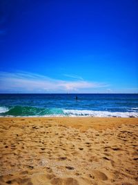 Scenic view of beach against blue sky