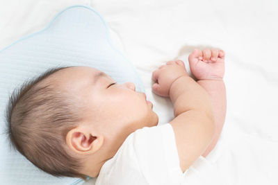 Close-up of baby boy lying on bed