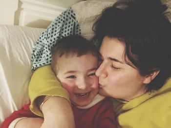 Portrait of mother and baby on bed