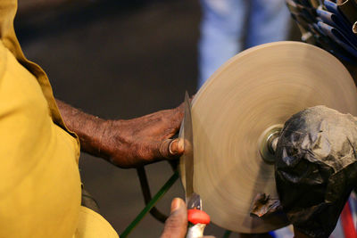 Midsection of worker sharpening knife