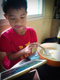 Boy holding mobile phone at table