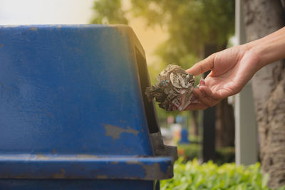 Cropped hand throwing waste in dustbin