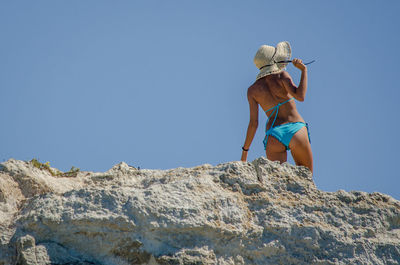 Low angle view of woman against blue sky