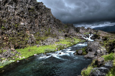 Scenic view of waterfall against sky