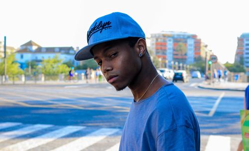 Side view portrait of young man standing on city street