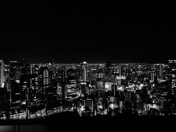 Illuminated cityscape against sky at night