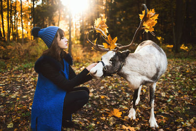 Side view of young woman with autumn leaves