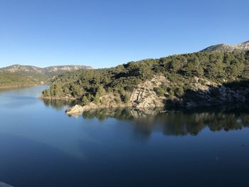 Scenic view of lake against clear blue sky