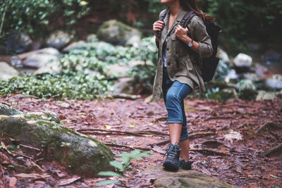 A female traveler with backpack walking into the woods