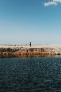 Man standing by river at atacama desert against sky