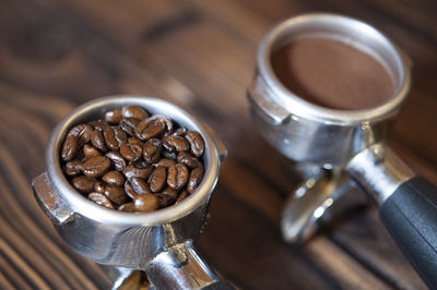 High angle view of coffee in containers on wooden table in cafe