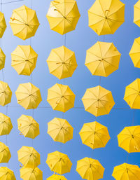 Full frame shot of yellow umbrellas against blue sky