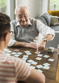 Senior man playing memory with his grandson