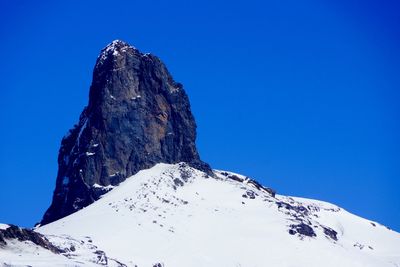 Low angle view of snow covered mountain against clear sky