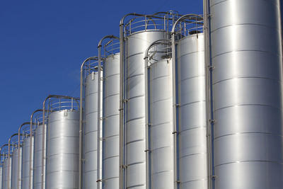 Low angle view of storage tank in factory against sky