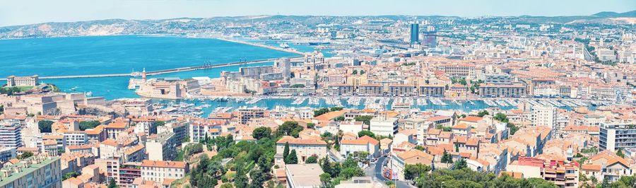 High angle view of city by sea against sky