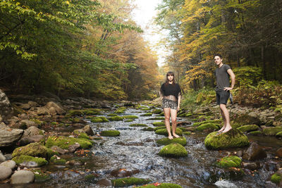 People standing by river in forest