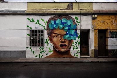 Portrait of man against graffiti wall