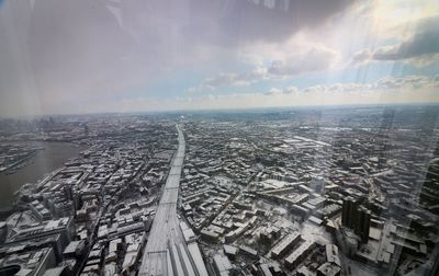 Digital composite image of buildings against cloudy sky