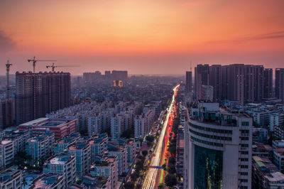 High angle view of modern buildings in city against sky during sunset