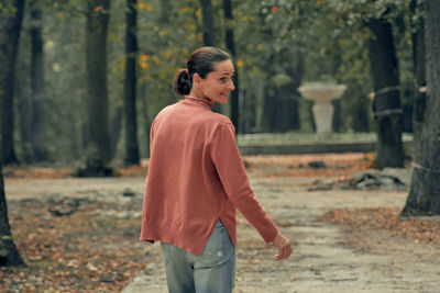 Side view of man standing in forest