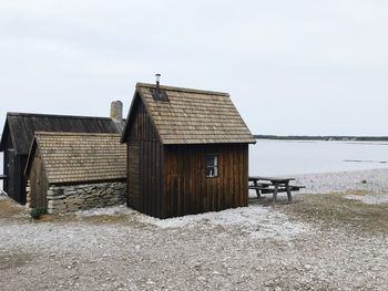 Huts on beach against clear sky