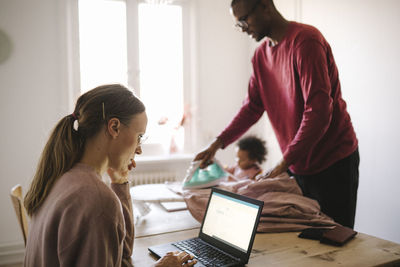 Family with daughter working and doing chores at home