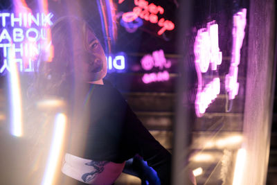 Rear view of woman holding illuminated string lights