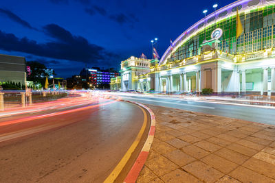 Light trails on road against buildings at night