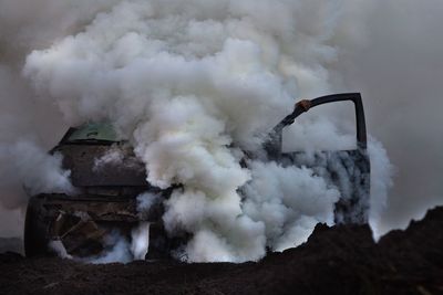 Smoke emitting from factory against sky