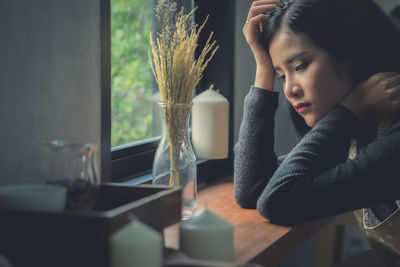 Close-up of girl sitting on table at home