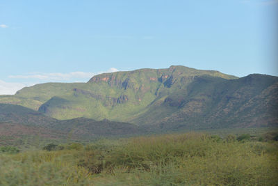 Scenic view of field and mountains against sky