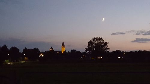 Silhouette trees against sky at night