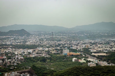 Crowded city houses landscape with misty mountain background at morning 