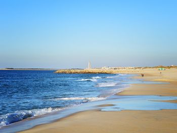 Scenic view of beach against clear sky