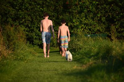 Rear view of friends walking on grass