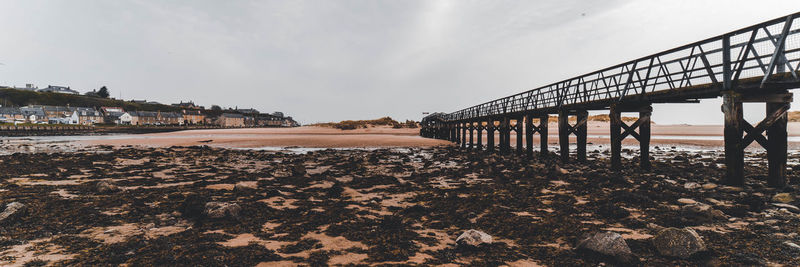 Pier on beach against sky