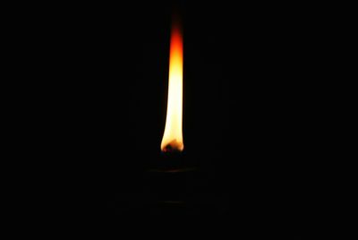 Lit candle in dark room