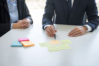 Midsection of business colleagues working at desk in office