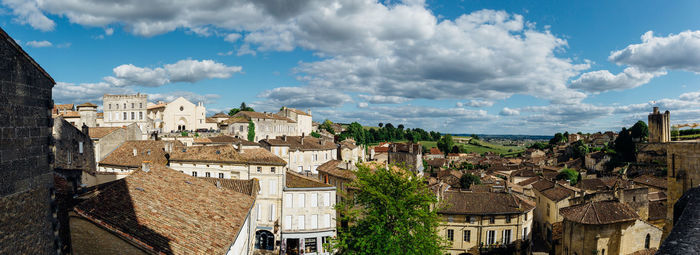 Buildings in city against cloudy sky