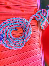 High angle view of multi colored tied on rope against wall