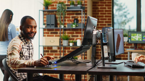 Portrait of smiling woman using laptop at table