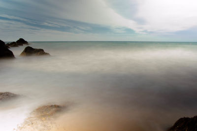 Scenic view of sea against cloudy sky