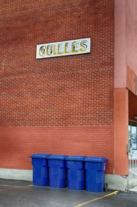 Garbage bin against brick wall