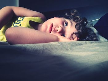 Portrait of cute boy lying on bed