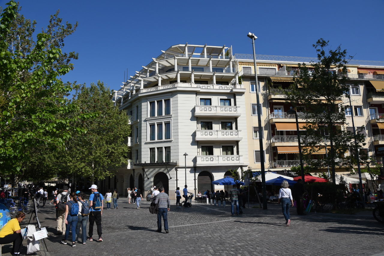 PEOPLE WALKING IN CITY AGAINST CLEAR SKY