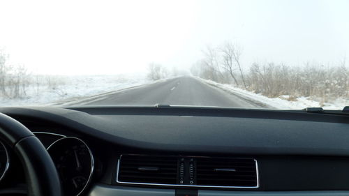 Car on road against clear sky during winter