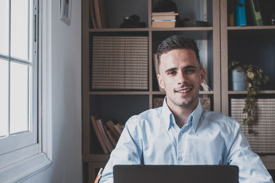 Portrait of young man using digital tablet at home