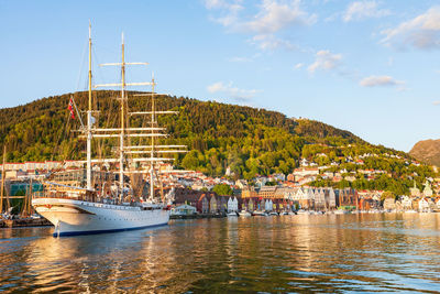 Sailboats moored at harbor against sky