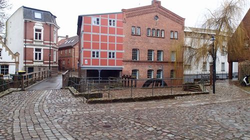 Old building by street against sky